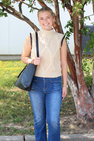 beige sweater with black trim